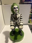 Exquisite Gaming: Warner Bros: Beetlejuice - Phone & Controller Holder. Fixed Price $18.00.
